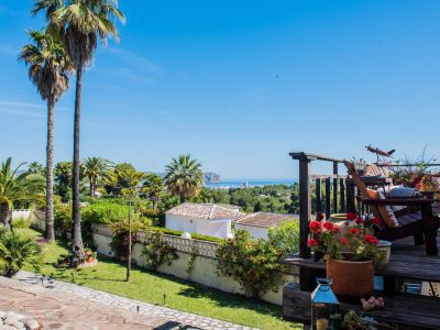 Blick von der Holzterrasse mit Bougainvillea und rustikalen Sesseln mit Blick auf das Mittelmeer.