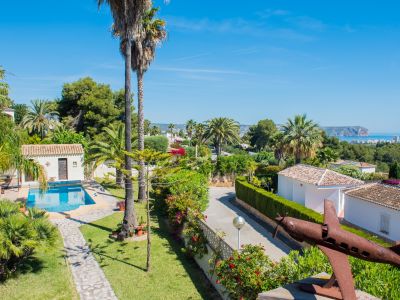 Erhöhte Ansicht des mediterranen Gartens mit Pool und verrosteter Flugzeugskulptur in Jávea.