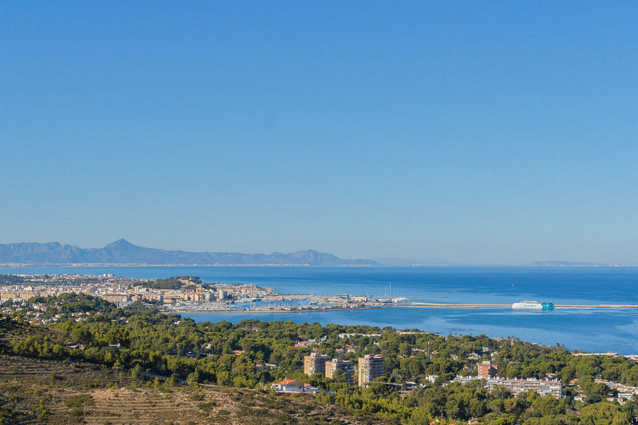 Panoramablick von der Immobilie auf den Hafen von Dénia und das Mittelmeer, mit der Baleària-Fähre und der fernen Küstenlinie.