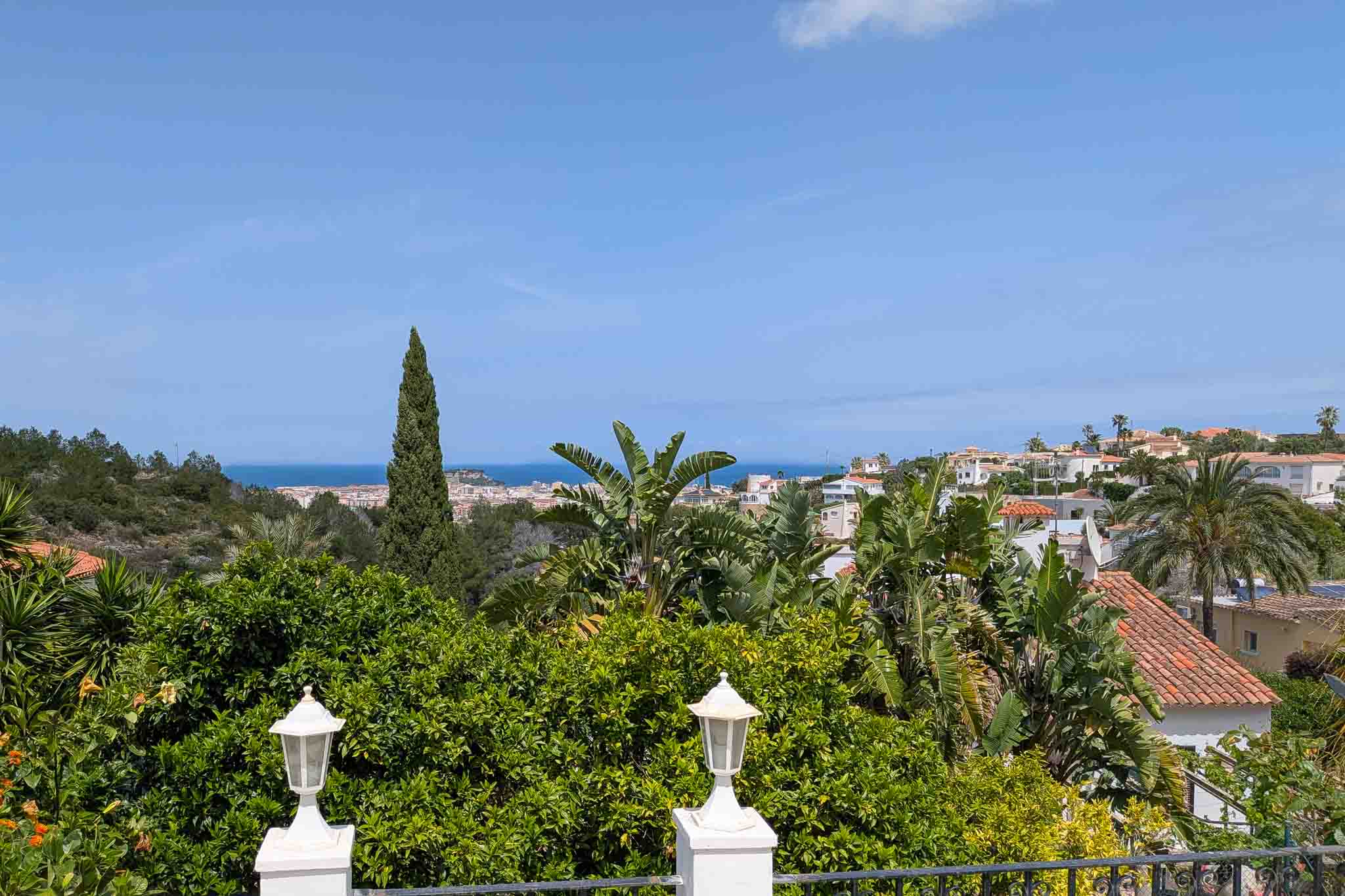 Panoramablick von der oberen Terrasse auf das Mittelmeer und Dénia, eingebettet in eine üppige mediterrane Gartenlandschaft.