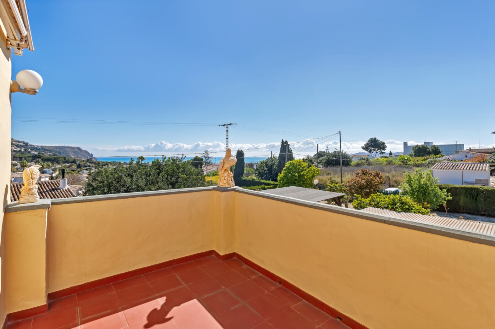 Hochgelegene Terrasse mit Terrakotta-Fliesen und Panoramablick auf das Mittelmeer und die umliegende Küstenlandschaft von Jávea.