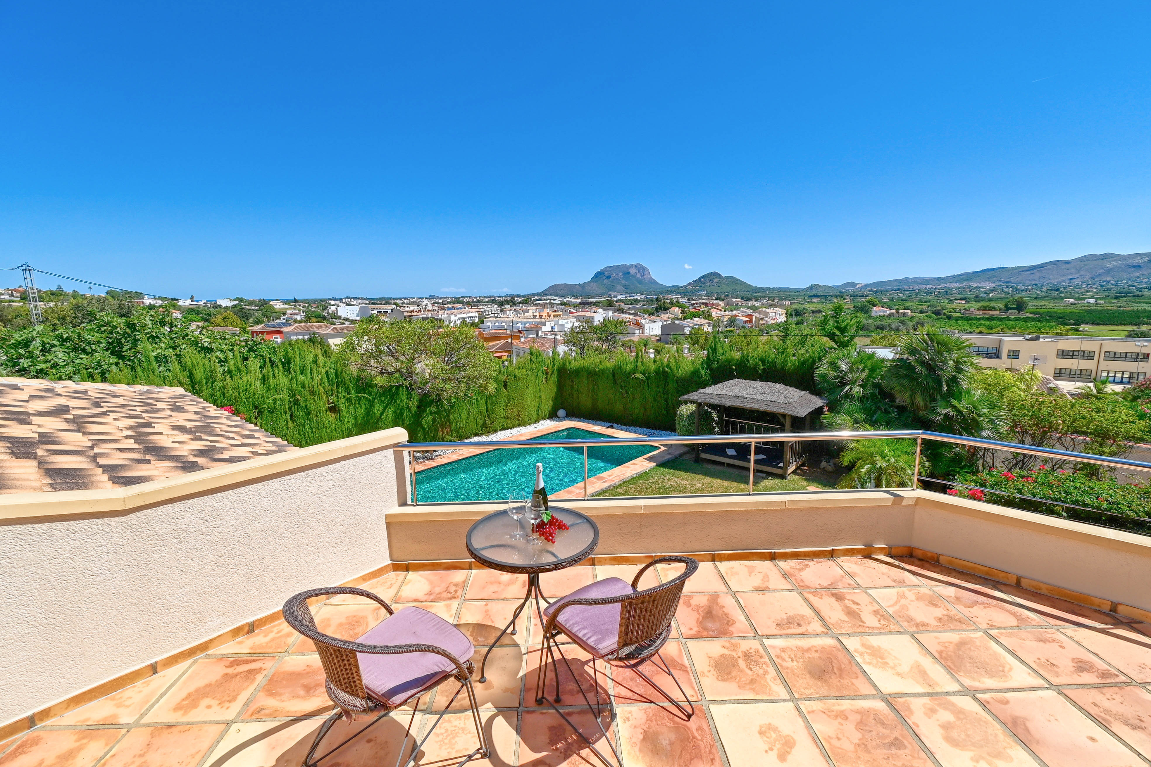 Terrasse mit Bistrotisch, mit Blick auf den Pool und die Berglandschaft von Denia.