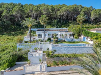 Außenansicht der Villa in Piver, Jávea, mit weißer Fassade, Pool und terrassenförmig angelegten Gärten mit mediterraner Vegetation.