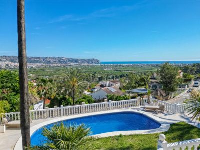 Erhöhte Ansicht des Pools mit weißem Geländer und Panoramablick auf das Meer und die Stadt.