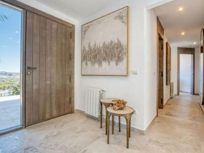 Helles Foyer mit Holztür und Marmorboden. Verfügt über abstrakte Kunstwerke und Beistelltische.