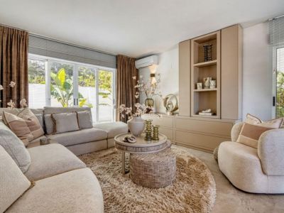 Helles Wohnzimmer mit modularem Sofa, rundem Hochflorteppich und integriertem Stauraum.