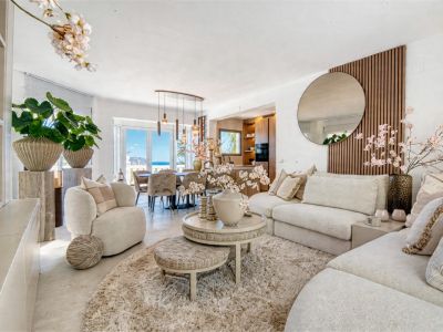 Helles Wohnzimmer mit neutralem Dekor, flauschigem Teppich und Zugang zum Essbereich mit Meerblick.