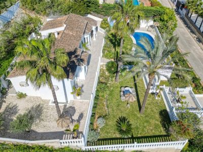 Luftaufnahme der Villa mit Garten, Pool und Terrasse. Mediterranes Design mit weißen Mauern und üppigem Grün.
