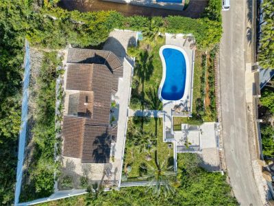 Luftaufnahme der Villa mit leuchtend blauem Pool, umgeben von Gärten und üppigem Grün in Jávea.
