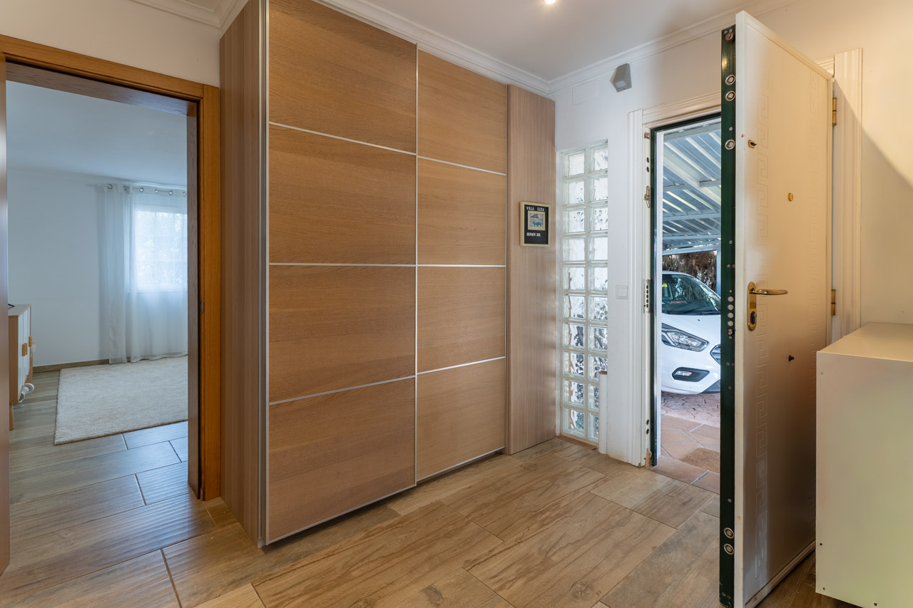 Eingangsbereich mit hellem Einbauschrank aus Holz und Sicherheitstür zur Garage.