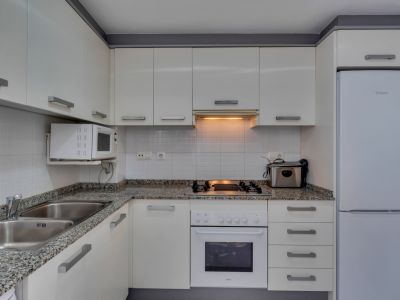 Funktionale Küche mit Granitarbeitsplatte, weißen Geräten und warmer Beleuchtung.