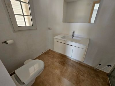 Gästetoilette mit modernem Waschtisch und cremefarbenem Fliesenboden.