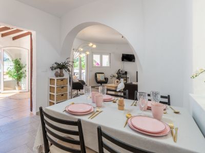 Heller Essbereich mit rosa-gold gedecktem Tisch, Zugang zur Terrasse und zum Wohnzimmer.
