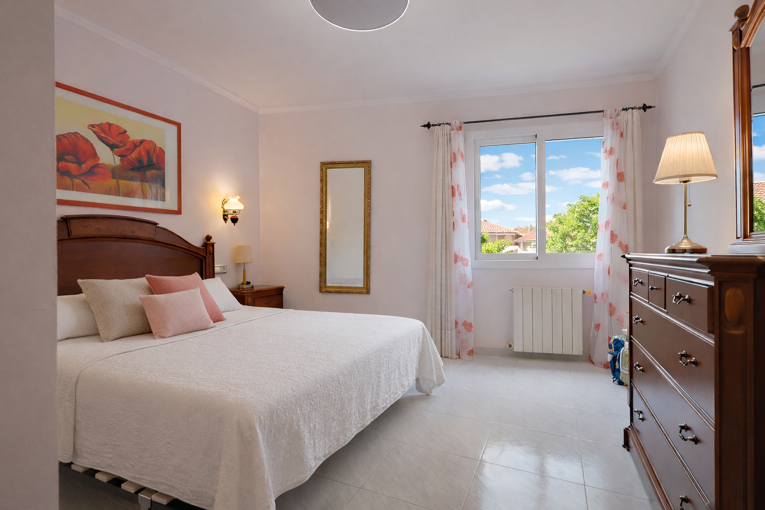 Helles Schlafzimmer mit Holzbett, klassischer Kommode und Blick nach draußen.