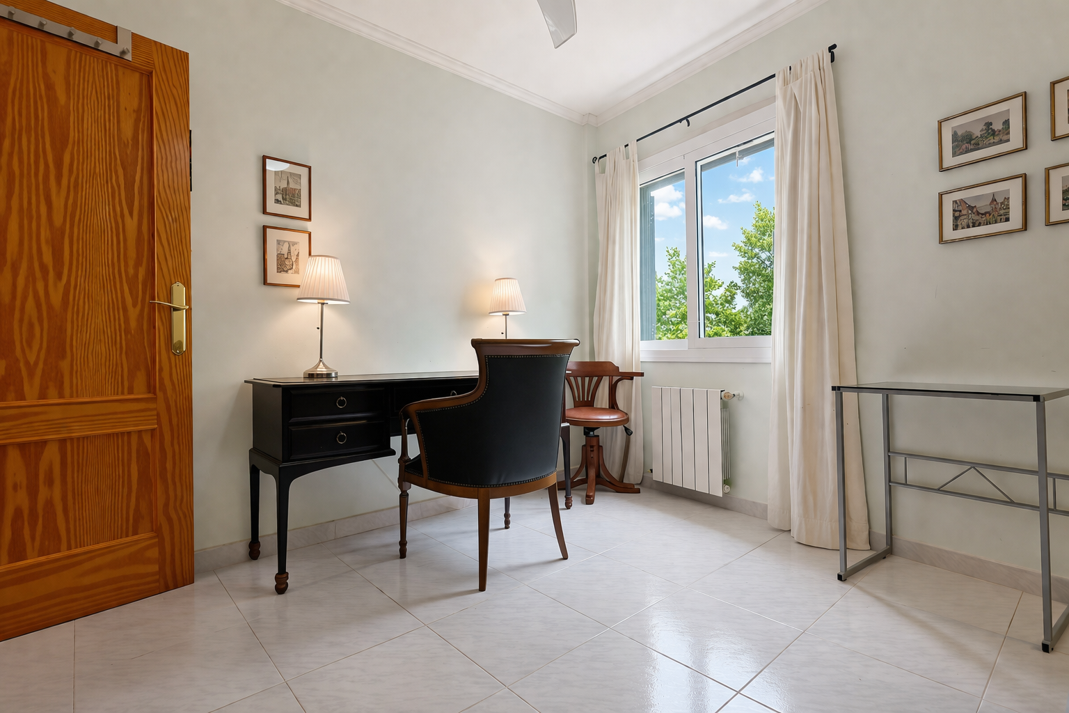 Helles Zimmer mit klassischem Schreibtisch aus dunklem Holz und gepolstertem Stuhl, ideal für ein Arbeitszimmer oder einen Arbeitsbereich.