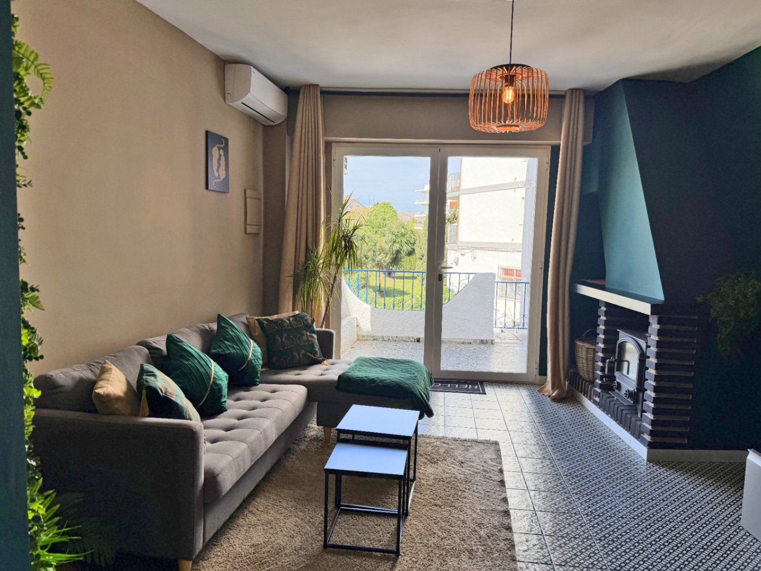 Helles Wohnzimmer mit Kamin und Terrassenzugang mit Außenblick.