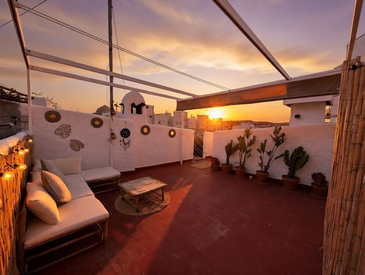 Private Dachterrasse mit Terrakottaboden, Topfpflanzen, Bambusmöbeln und Blick auf den Sonnenuntergang.
