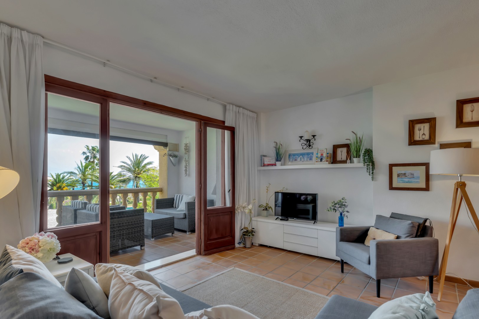 Helles Wohnzimmer mit verglaster Terrasse und Blick auf das Mittelmeer in Jávea.