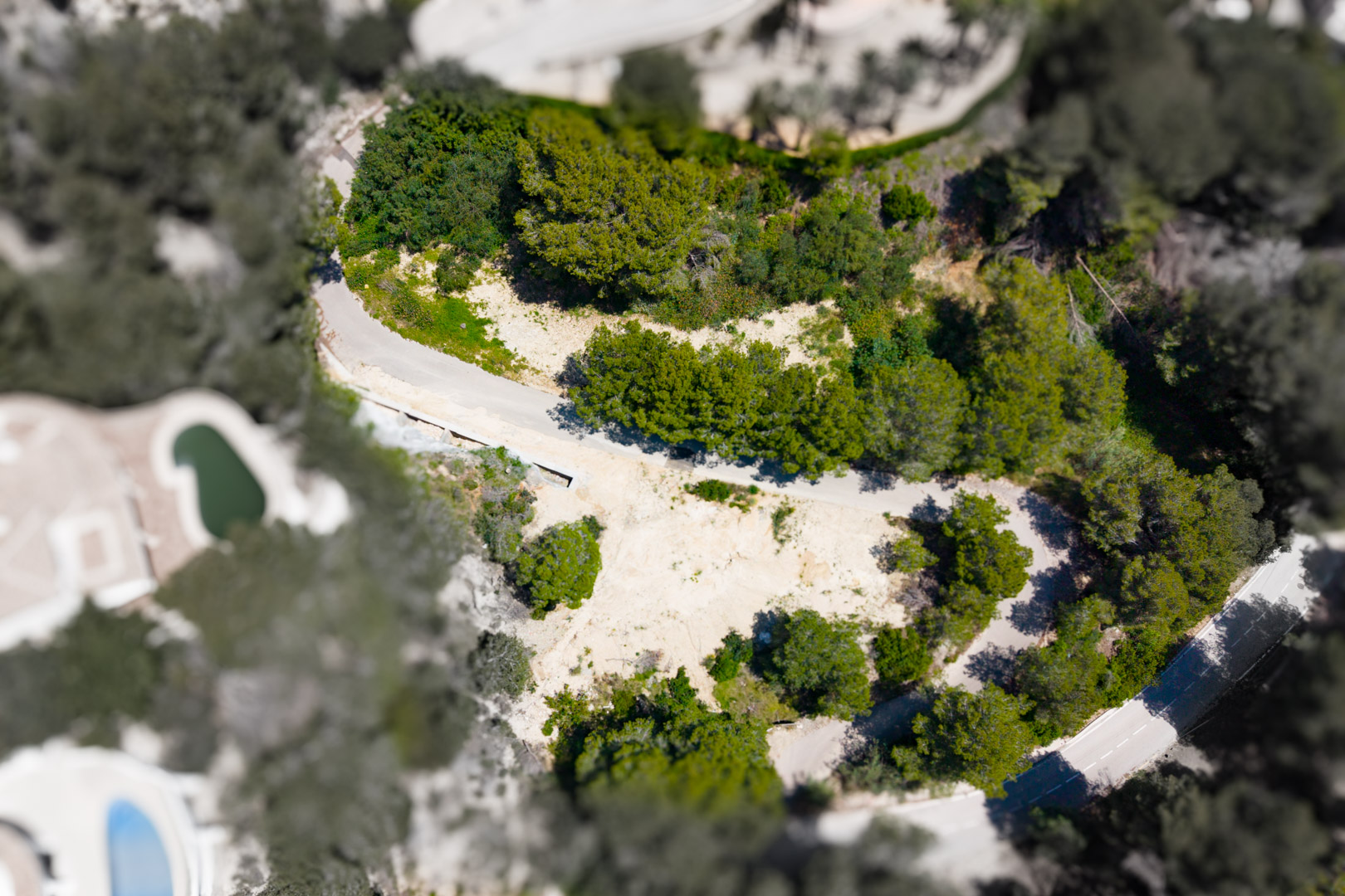 Luftaufnahme eines Grundstücks in Mar Azul, Jávea, mit unbebautem Land, umgeben von Grün.