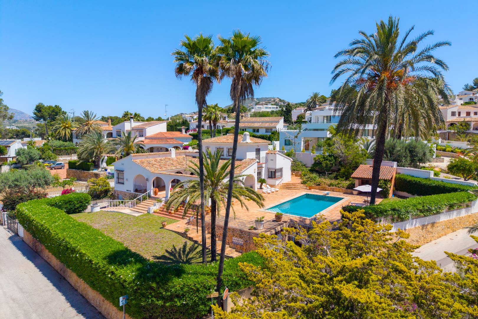 Luftaufnahme der Villa mit Pool, umgeben von Gärten und Palmen.