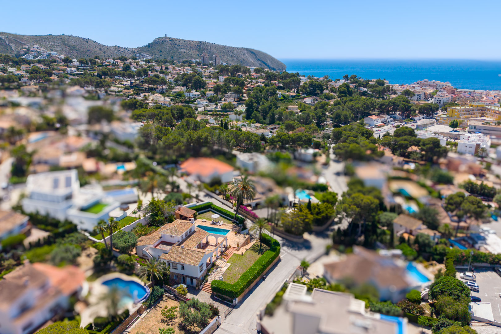 Luftaufnahme der Villa mit Pool und Steinbögen, umgeben von mediterranem Grün.