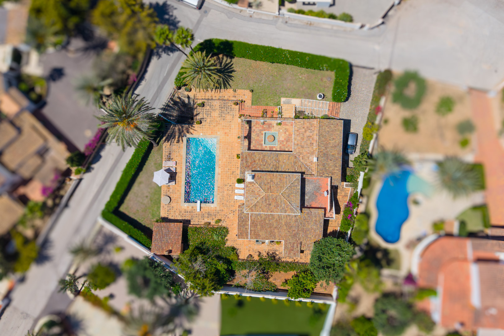 Luftaufnahme der Villa mit rechteckigem Pool und rotem Ziegeldach.