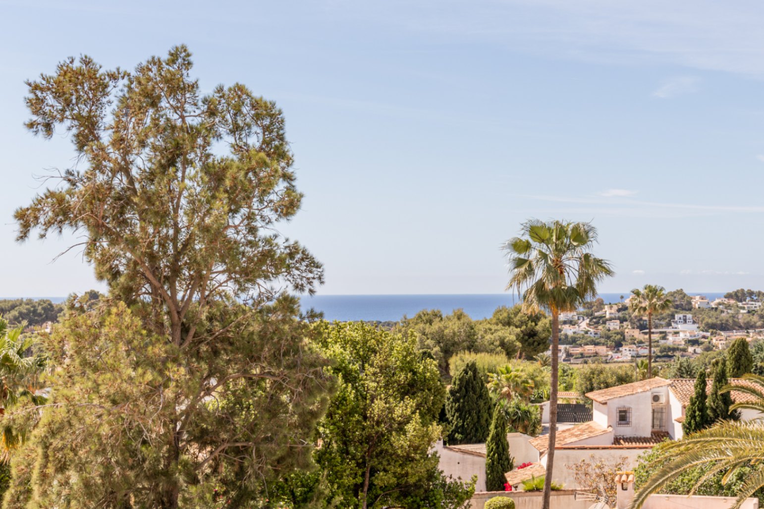 Panoramablick von der Villa, mit dem Mittelmeer am Horizont, üppiger Vegetation und Wohnhäusern mit Terrakottadächern.