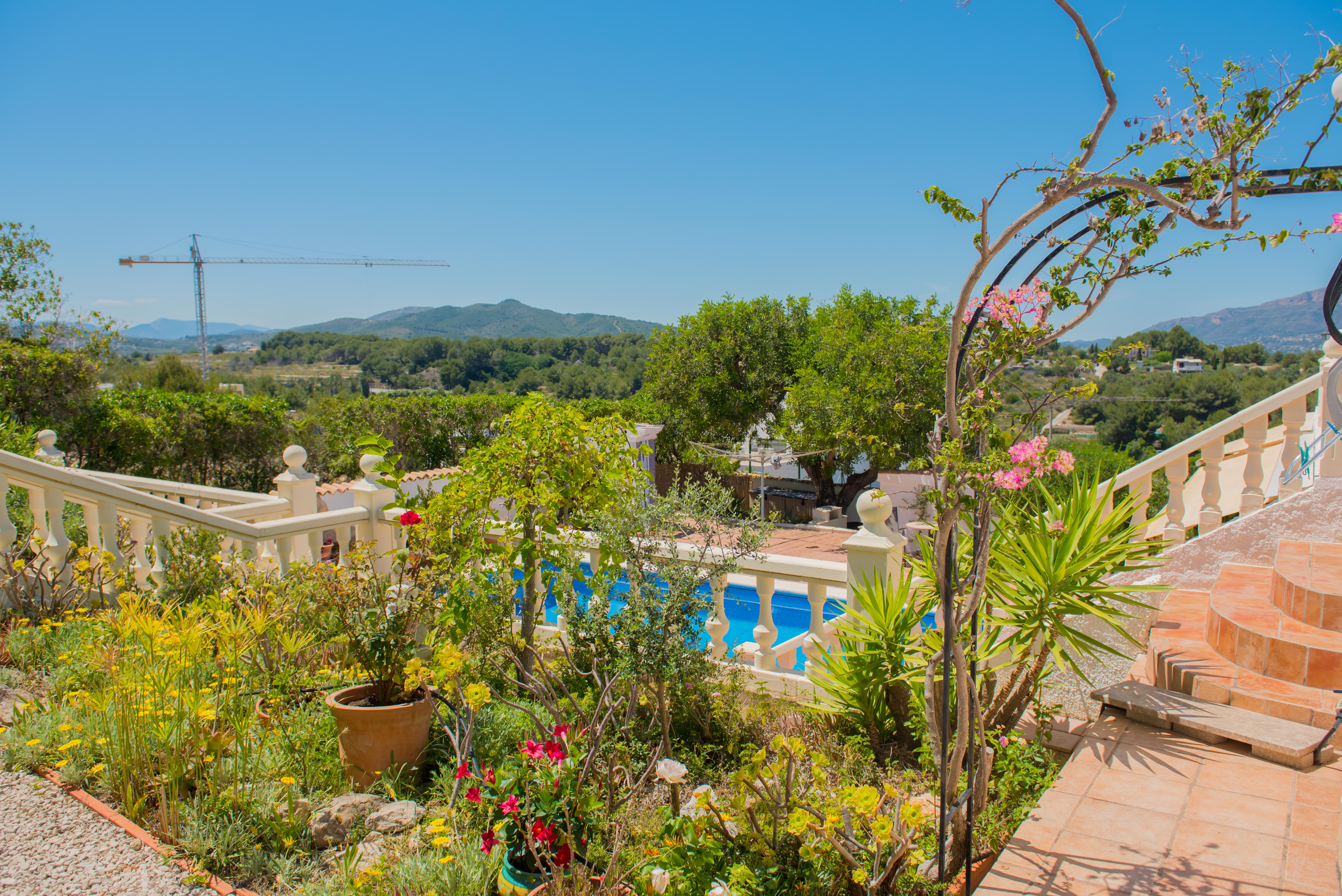 Mediterraner Garten mit Poolblick und Kalksteinbalustrade.