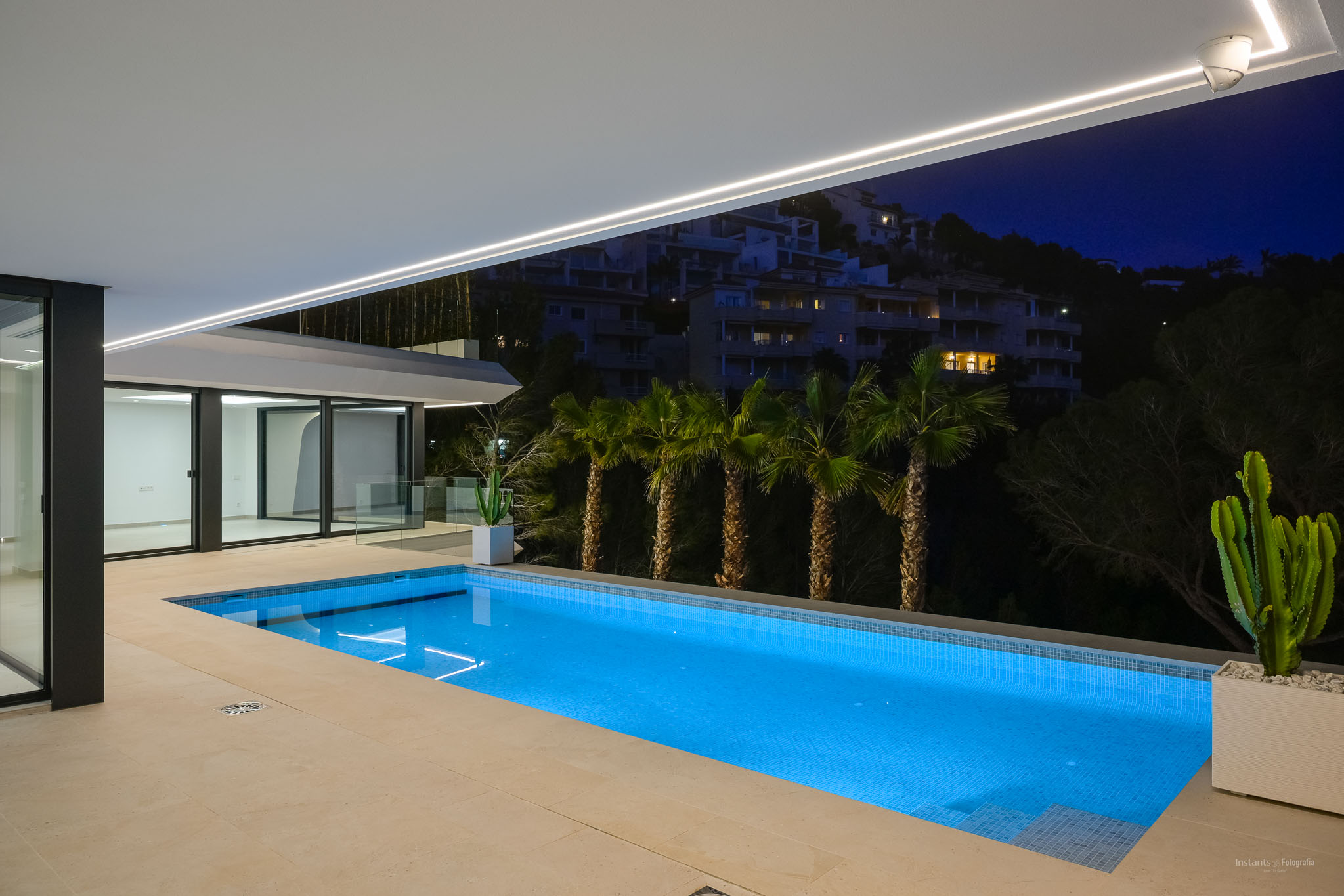 Moderner Infinity-Pool mit Sonnenterrasse und Panoramablick auf das Mittelmeer. Der Außenbereich zeigt zeitgenössisches Design und üppige, pflegeleichte Bepflanzung.