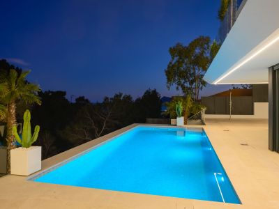 Beheizter Gegenstrom-Pool und Außen-Spa, umgeben von einem mediterranen Garten mit Panoramablick auf das Meer.