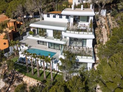 Luftaufnahme einer modernen, mehrstöckigen weißen Villa, eingebettet in einen grünen Hang. Mit großem privaten Pool, weitläufigen Terrassen mit Glasgeländer und Palmen, umgeben von mediterranem Wald.