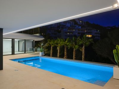 Moderner Infinity-Pool mit Sonnenterrasse und Panoramablick auf das Mittelmeer. Der Außenbereich zeigt zeitgenössisches Design und üppige, pflegeleichte Bepflanzung.
