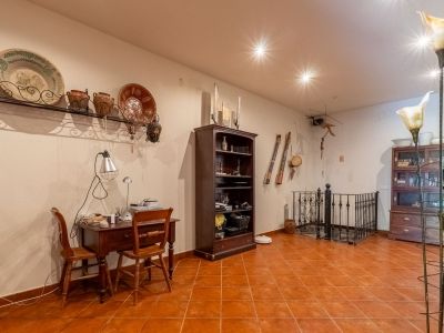 Funktionaler Arbeitsbereich mit Holzschreibtisch, Terrakotta-Bodenfliesen und traditioneller Wanddekoration. Der Raum umfasst ein Bücherregal und ein schmiedeeisernes Geländer.