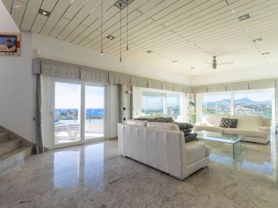 Geräumiges Wohnzimmer mit polierten Granitböden, Lamellendecken und Panoramablick auf Meer und Berge, direkter Zugang zur Terrasse und zum Pool.