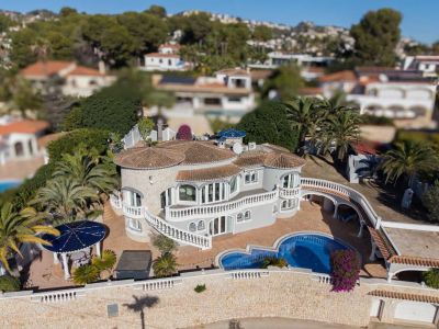 Luftaufnahme der Luxusvilla mit ihrer markanten Architektur, privatem Pool, mehreren Terrassen mit weißen Balustraden und üppigem mediterranem Garten.
