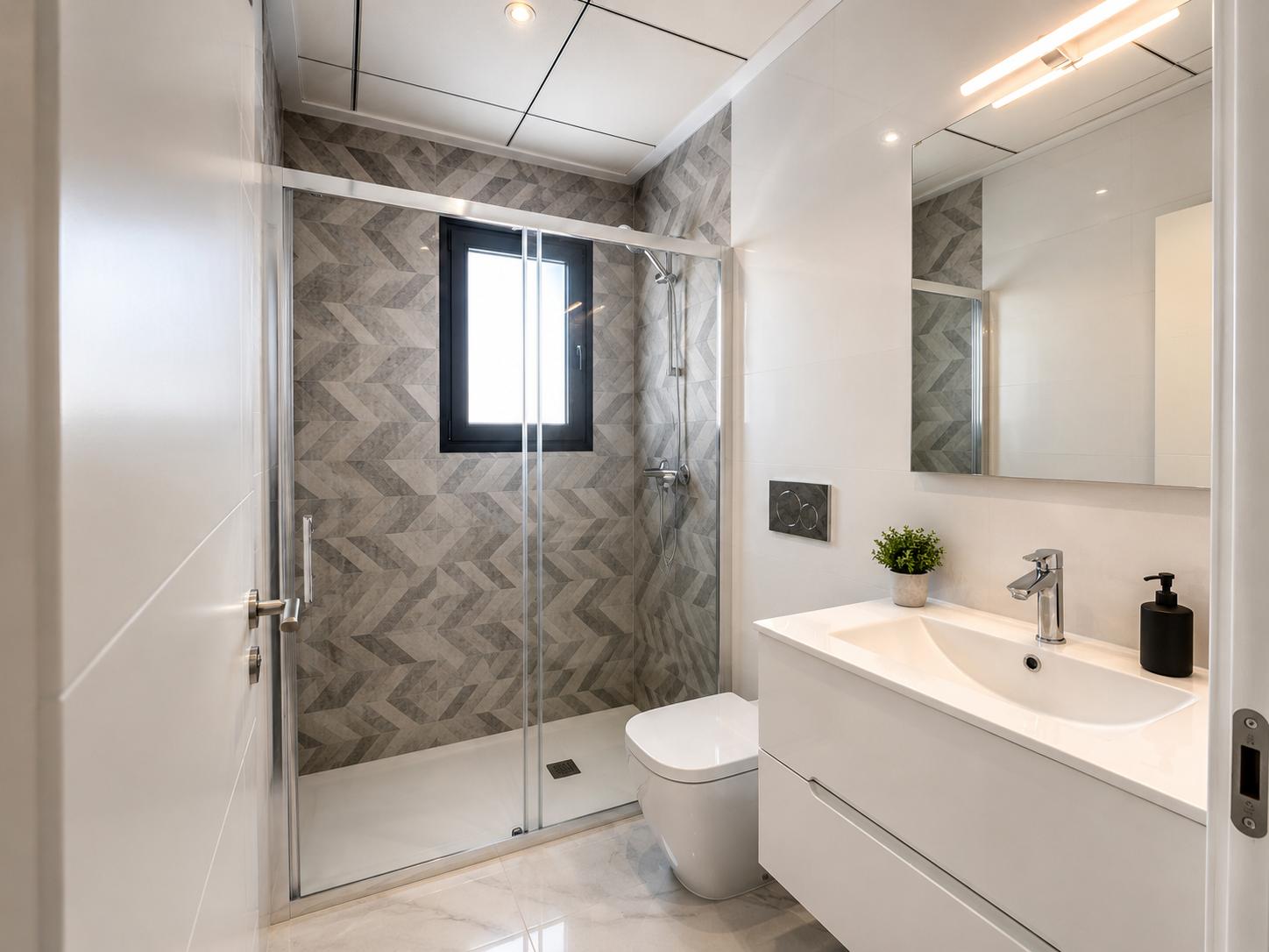 Modernes Badezimmer mit ebenerdiger Dusche, Glaswand, grauen geometrischen Wandfliesen und Fenster. Weißer schwebender Waschtisch über Marmoroptik-Boden.