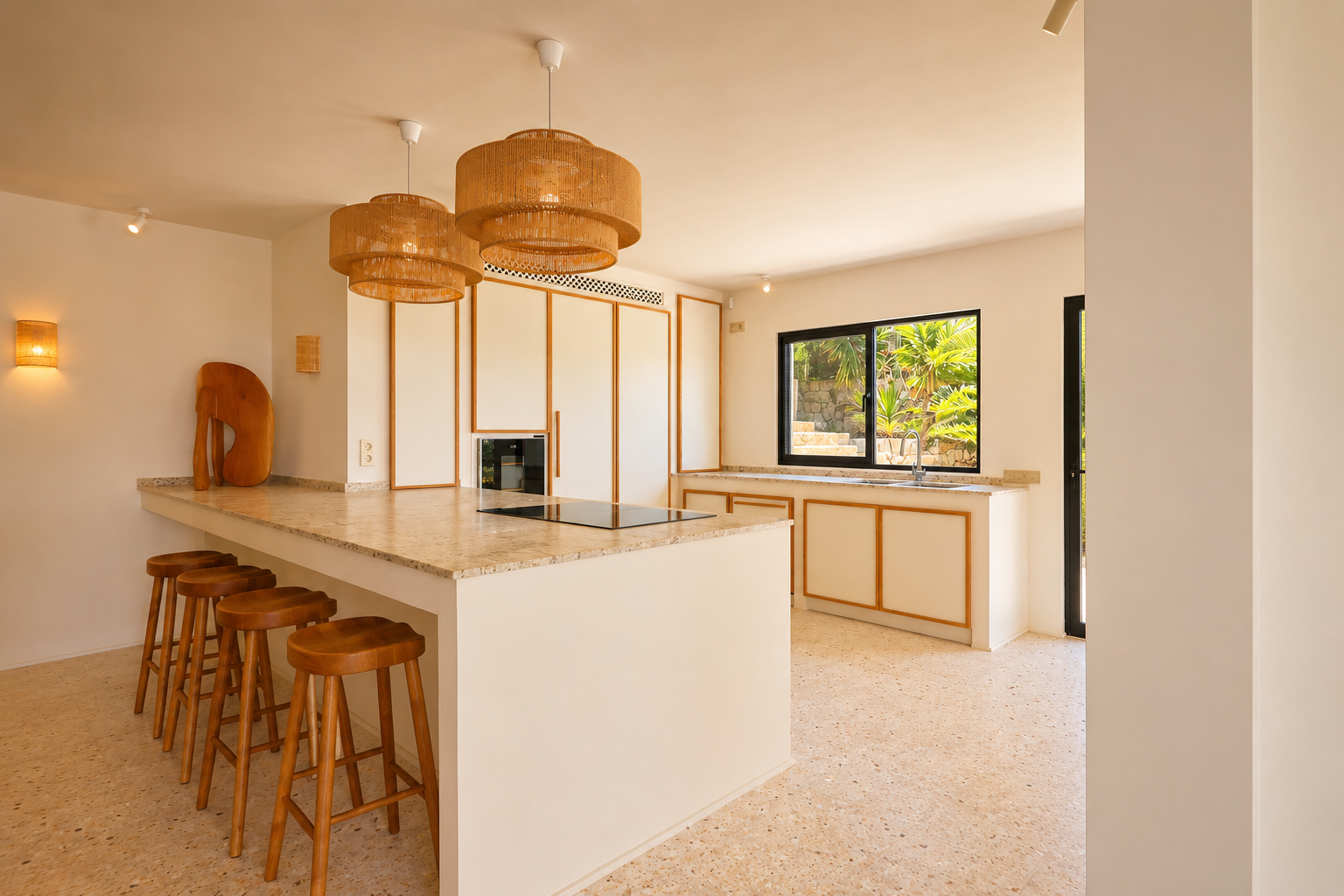 Moderne Kücheninsel mit integriertem Kochfeld, heller, gesprenkelter Arbeitsplatte und fünf Holzbarhockern. Geflochtene Pendelleuchten erhellen den Raum, mit Blick auf üppiges Grün im Freien.
