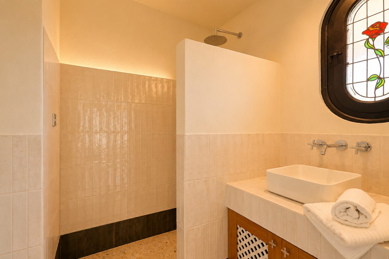 Modernes Badezimmer mit ebenerdiger Dusche, Regenduschkopf und indirekter LED-Beleuchtung. Aufsatzwaschbecken auf gefliester Ablage und ovales Buntglasfenster mit Rosenmotiv.