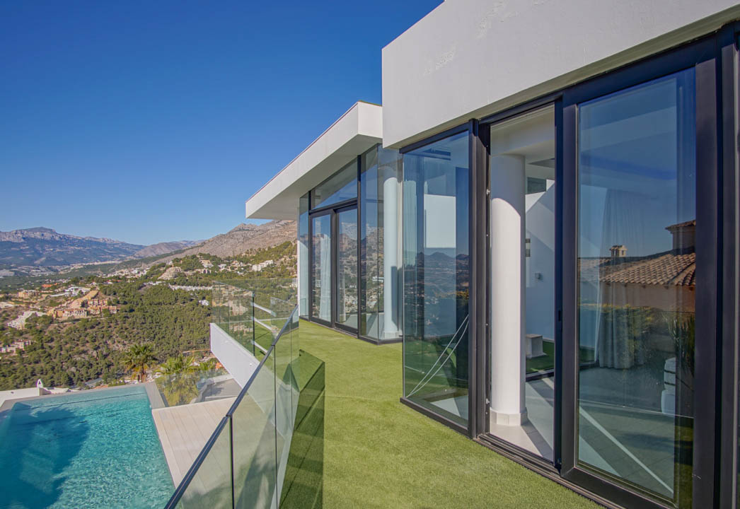Der geräumige, lichtdurchflutete Wohnbereich verfügt über einen modernen Gaskamin und große Fenster, die einen atemberaubenden Meer- und Bergblick bieten.