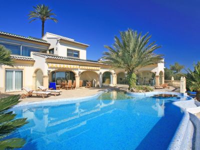 Großer blauer Mosaikpool mit Strandzugang, Palmeninsel und Wassertisch. Die Villa verfügt über eine überdachte Naya und einen verglasten Fitnessraum.