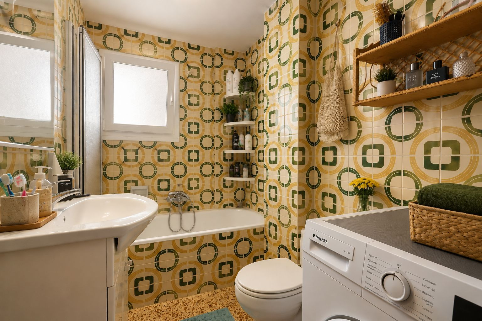 Das Badezimmer zeigt charakteristische gelb-grüne geometrische Fliesen, einen Waschtisch mit Unterschrank, eine Badewanne mit Duschwand und eine integrierte Waschmaschine, beleuchtet durch ein Fenster. Das Badezimmer zeigt charakteristische gelb-grüne geometrische Fliesen, einen Waschtisch mit Unterschrank, eine Badewanne mit Duschwand und eine integrierte Waschmaschine, beleuchtet durch ein Fenster.