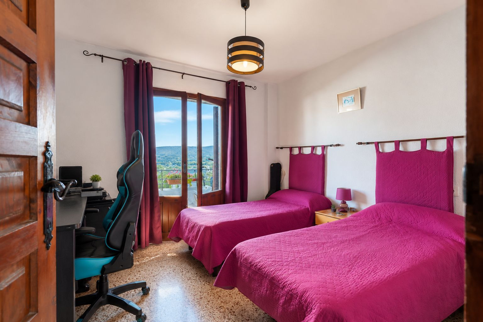 Helles Schlafzimmer mit zwei Einzelbetten, fuchsiafarbenen Kopfteilen und direktem Balkonzugang mit Bergblick. Ein Schreibtischbereich und Terrazzoboden sind vorhanden. Helles Schlafzimmer mit zwei Einzelbetten, fuchsiafarbenen Kopfteilen und direktem Balkonzugang mit Bergblick. Ein Schreibtischbereich und Terrazzoboden sind vorhanden.
