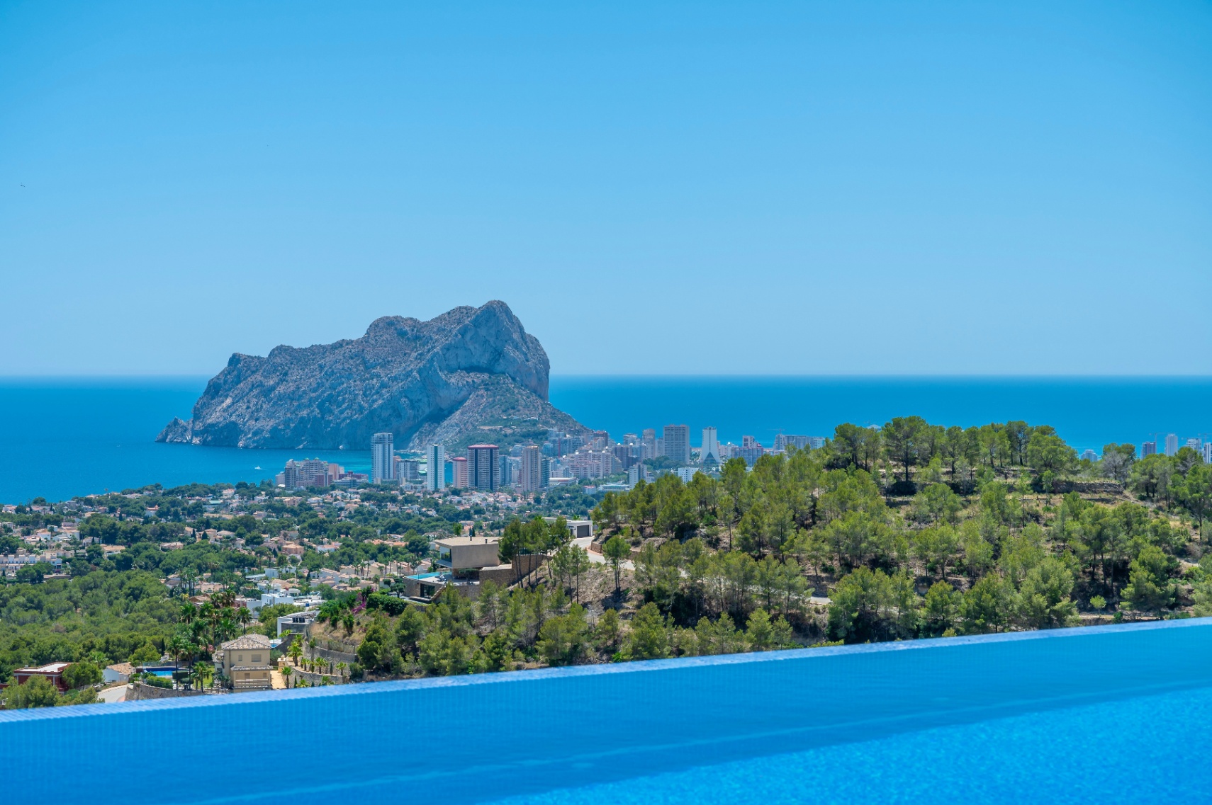 Infinity-Poolrand mit Panoramablick auf das Mittelmeer, die Stadt Calpe und den markanten Felsen Peñon de Ifach. Infinity-Poolrand mit Panoramablick auf das Mittelmeer, die Stadt Calpe und den markanten Felsen Peñon de Ifach.