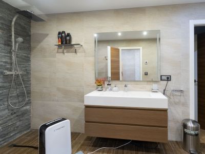 Modernes Badezimmer mit Regendusche und Schiefer-Akzentwand, schwebendem Holzwaschtisch und integriertem Waschbecken. Fliesen in Holzoptik.