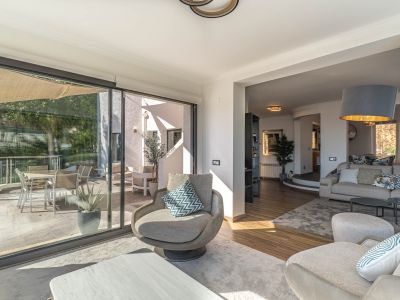 Modernes Wohnzimmer mit großen Glastüren, die sich nahtlos zur Terrasse öffnen und einen atemberaubenden Panoramablick auf das Mittelmeer sowie reichlich Tageslicht bieten.