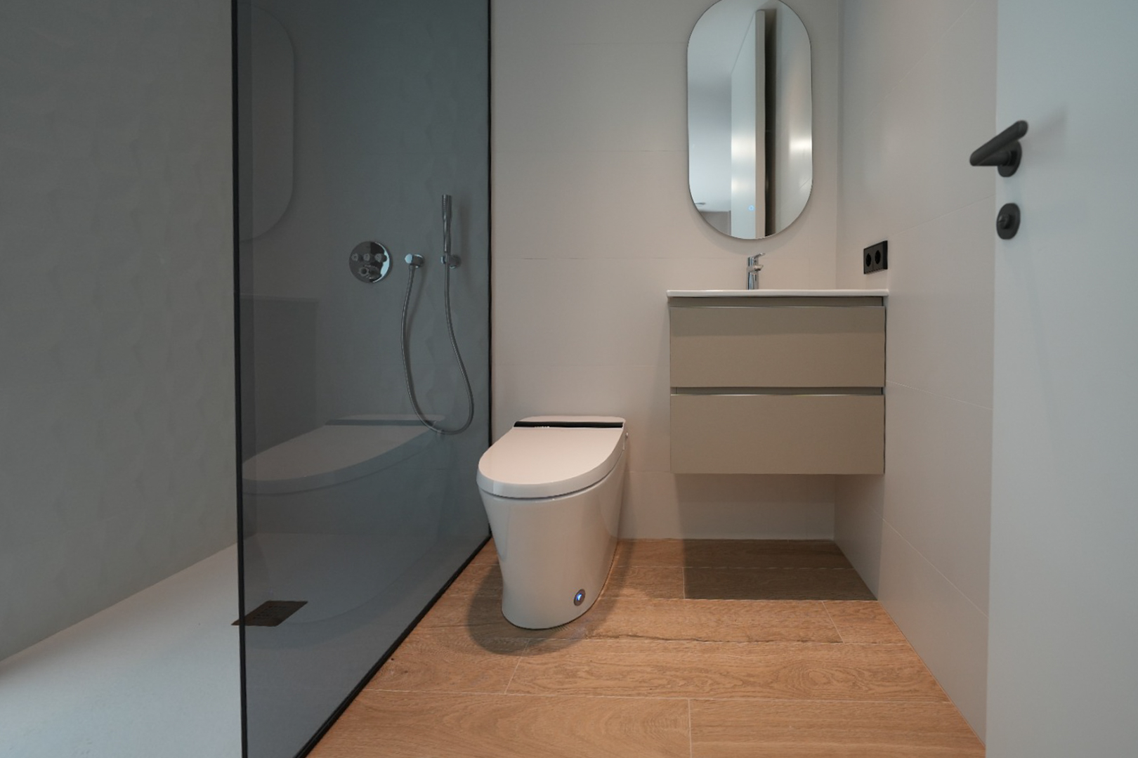 Modernes Badezimmer mit ebenerdiger Dusche, dunkler Glaswand und strukturierter grauer Wand, wandhängendem WC, schwebendem Waschtisch und hellem Holzfliesenboden.