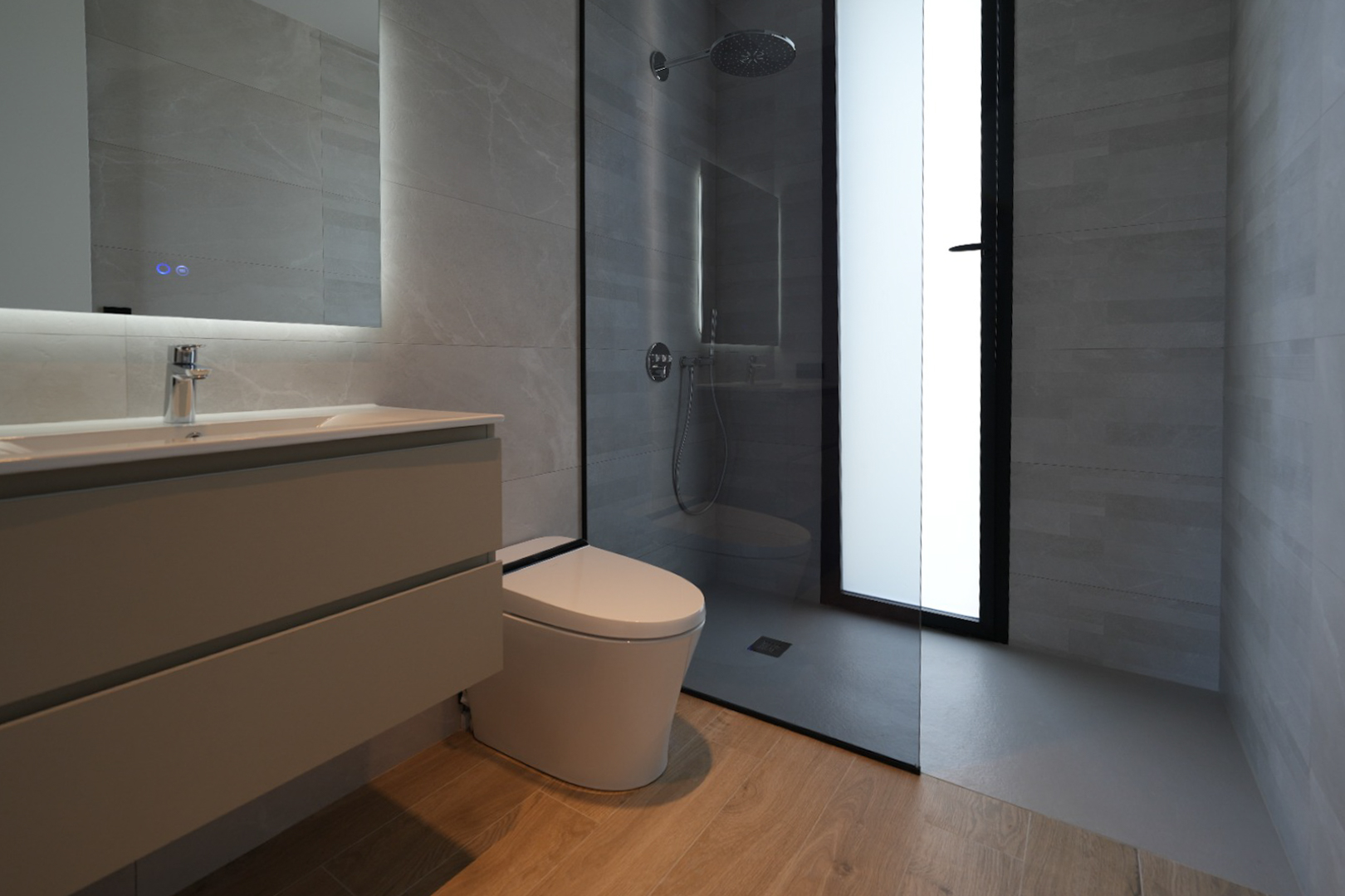 Modernes Badezimmer mit schwebendem Waschtisch, beleuchtetem Spiegel, wandhängendem WC und ebenerdiger Dusche mit Regenduschkopf, ergänzt durch graue Fliesen und Holzbodenoptik.