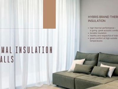 Innenansicht, die die fortschrittliche Wärmedämmung der Wände veranschaulicht, mit einem modernen Ecksofa und transparenten Vorhängen.