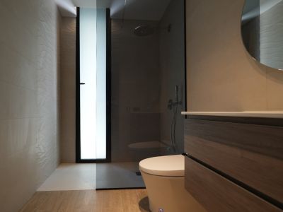 Modernes Badezimmer mit Holzwaschtisch, Rundspiegel und begehbarer Dusche. Strukturierte Wandfliesen und ein Milchglasfenster.