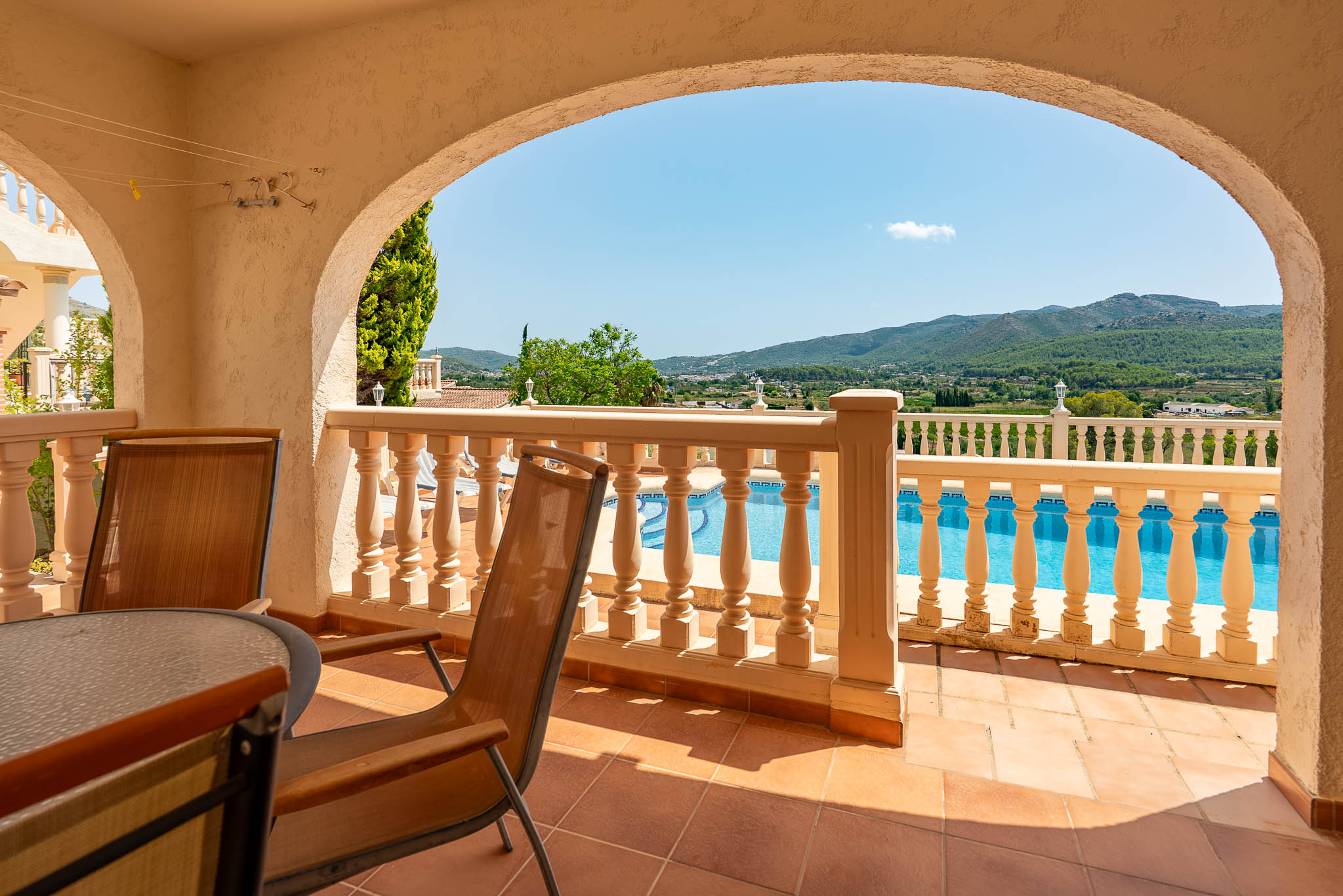 Überdachte Terrasse mit Poolblick